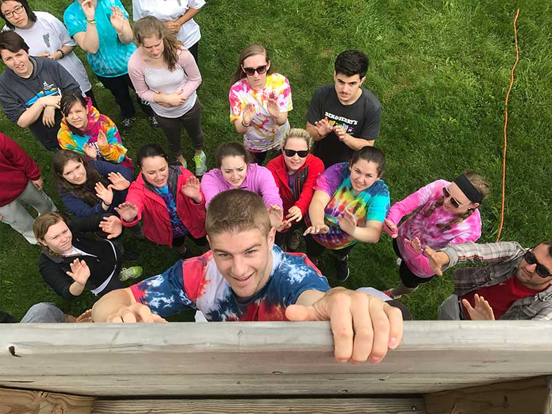 Group boosts student over a group team wall
